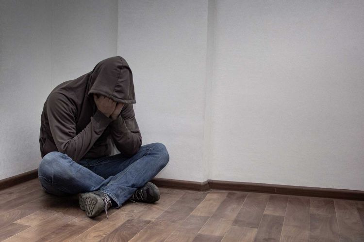 A mad covering his face in sadness.