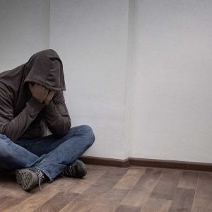 A mad covering his face in sadness.