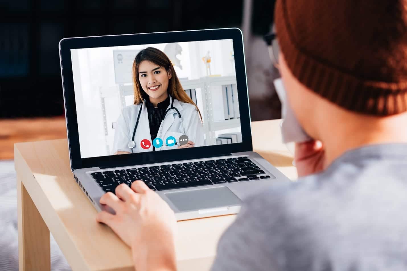 patient using laptop to video call conferencing with female doctor from home