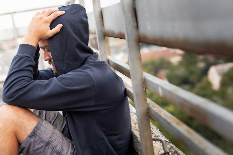 A man sitting and thinking about drug rehab.