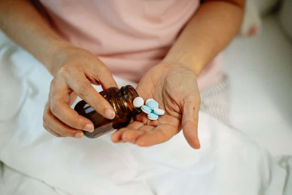a person pours pills into their hand