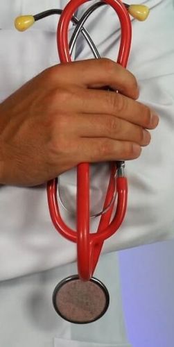 a doctor holds a stethescope with their arms crossed