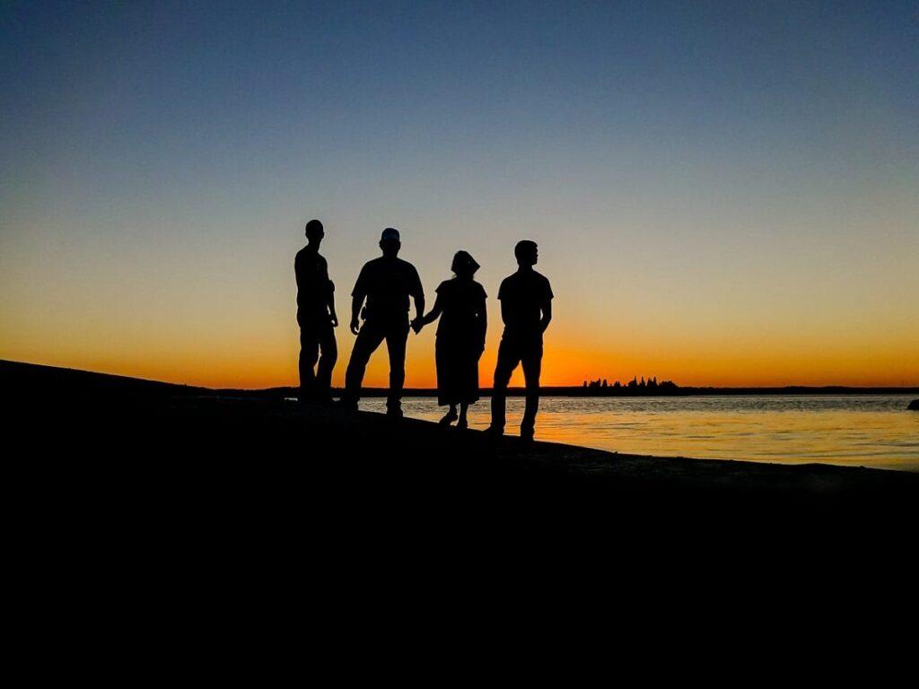 a group on the beach at sunset