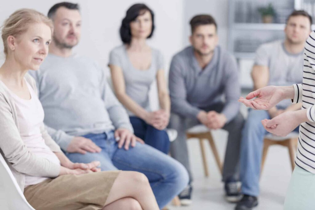 a group listens to a therapist
