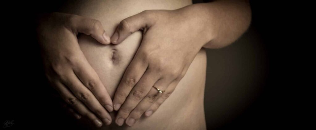 a person holds their stomach in the shape of a heart