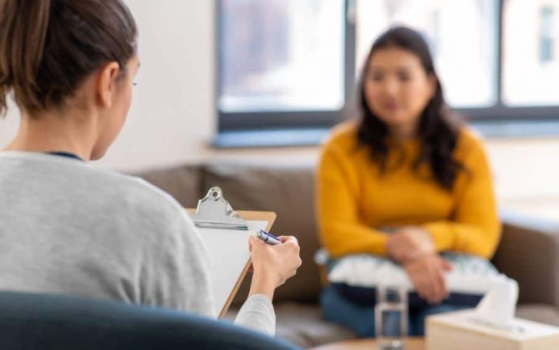 a therapist reads off of a clipboard to a person