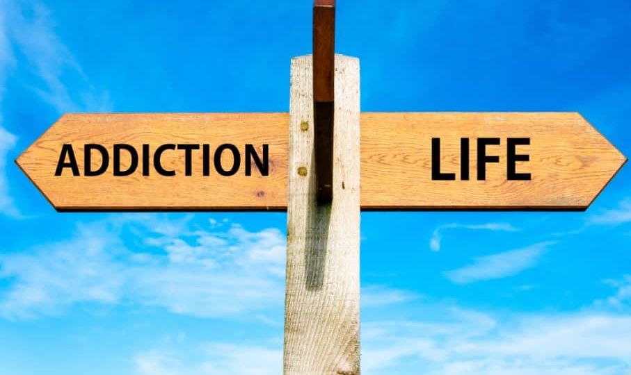 two arrow signs reading "addiction" and "life" pointing in different directions