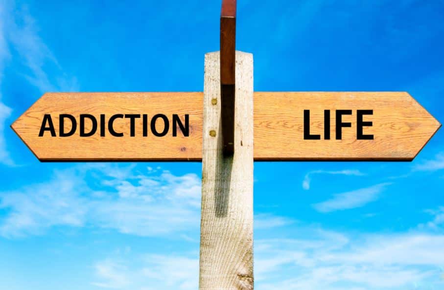 two arrow signs reading "addiction" and "life" pointing in different directions