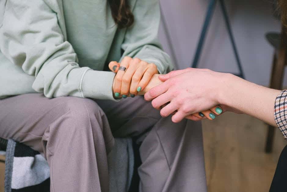 a therapist holds a person's hands in support