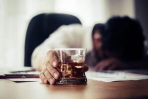 a person passed out holding a glass of liquor