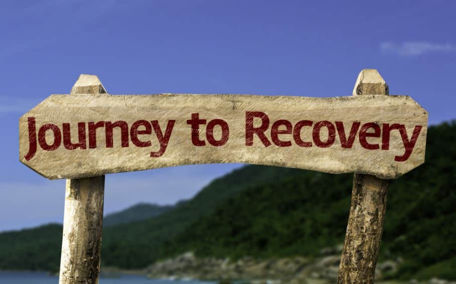a sign near a mountain beach that reads "journey to recovery"
