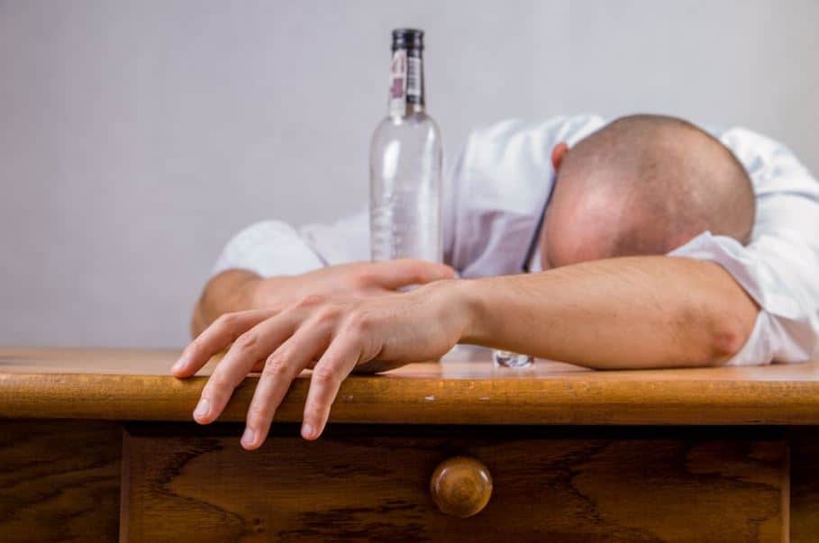 a person passed out holding an empty liquor bottle