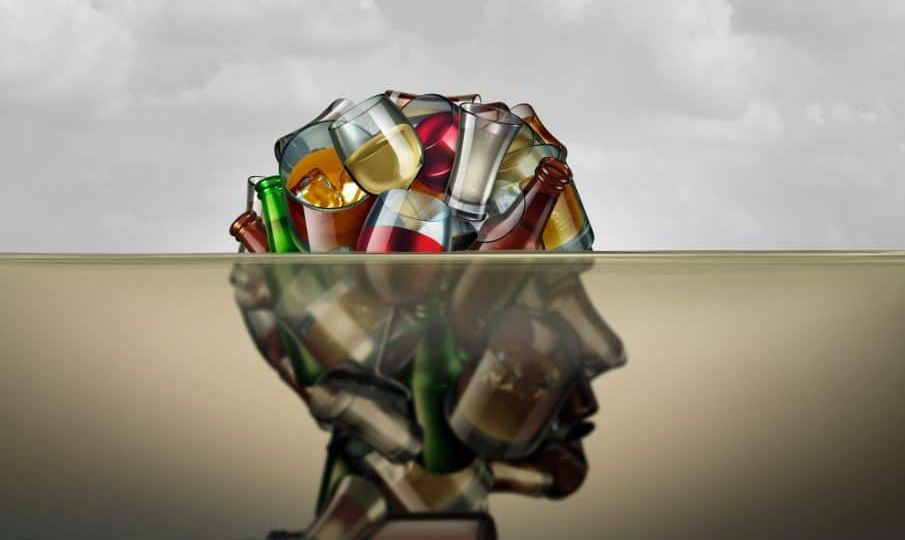 an artful image of a human head made of alcohol bottles that is partially below water
