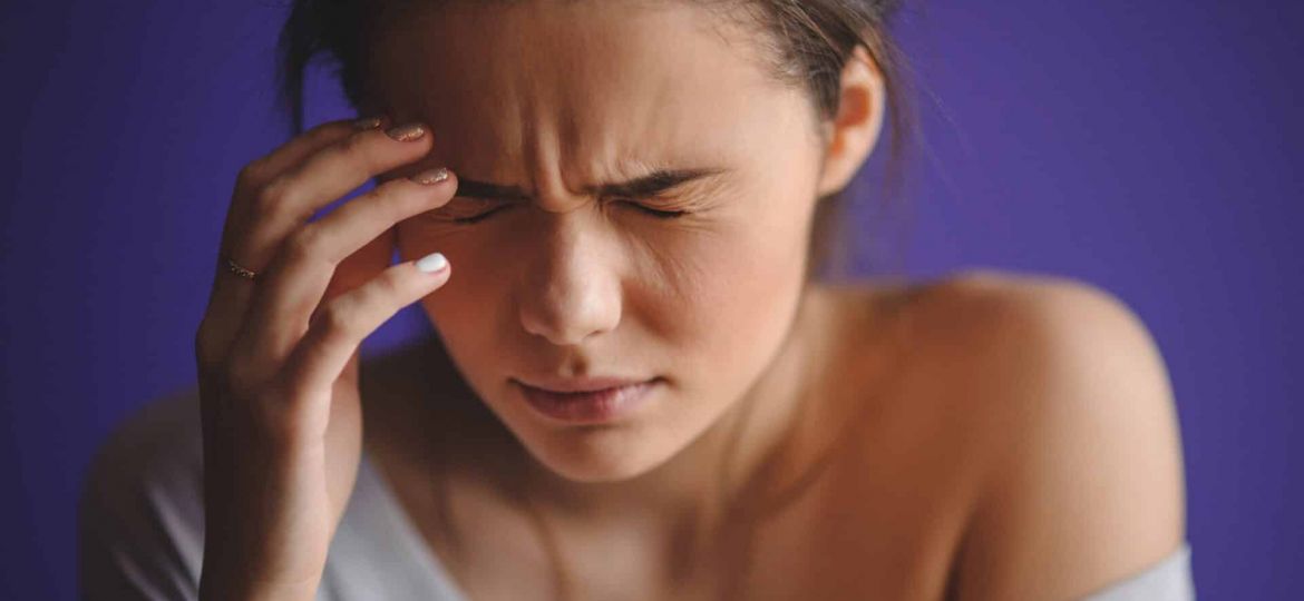 a person holds their head in pain