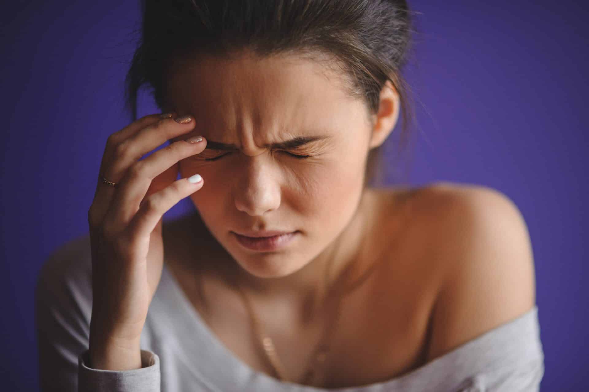 a person holds their head in pain