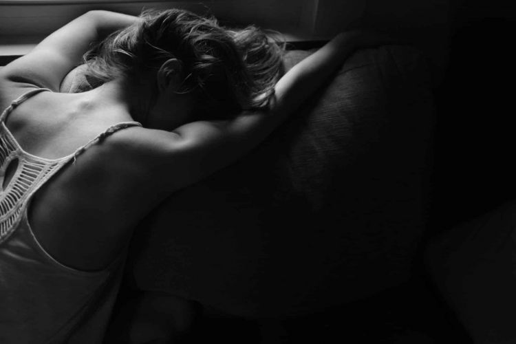 a person leans on a couch dramatically