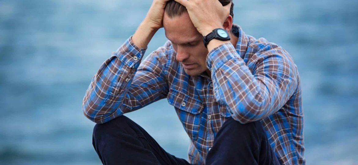 a person holds their head in agony
