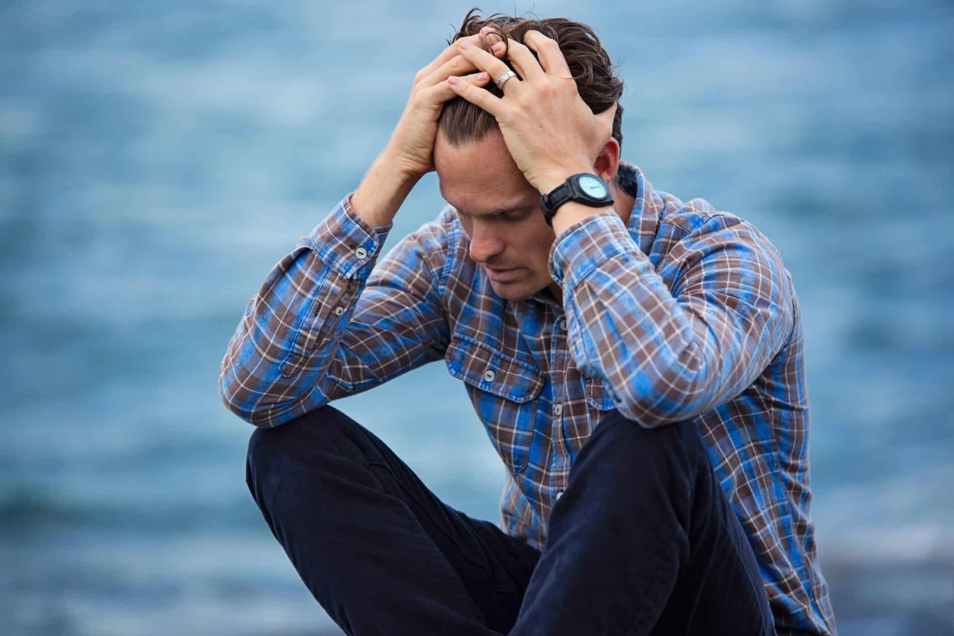 a person holds their head in agony