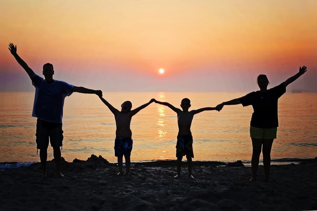 a family links arms on a beach