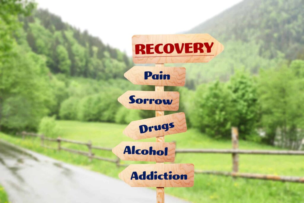 arrow signs that read "recovery" "pain" "sorrow" "drugs' "alcohol" "addiction"