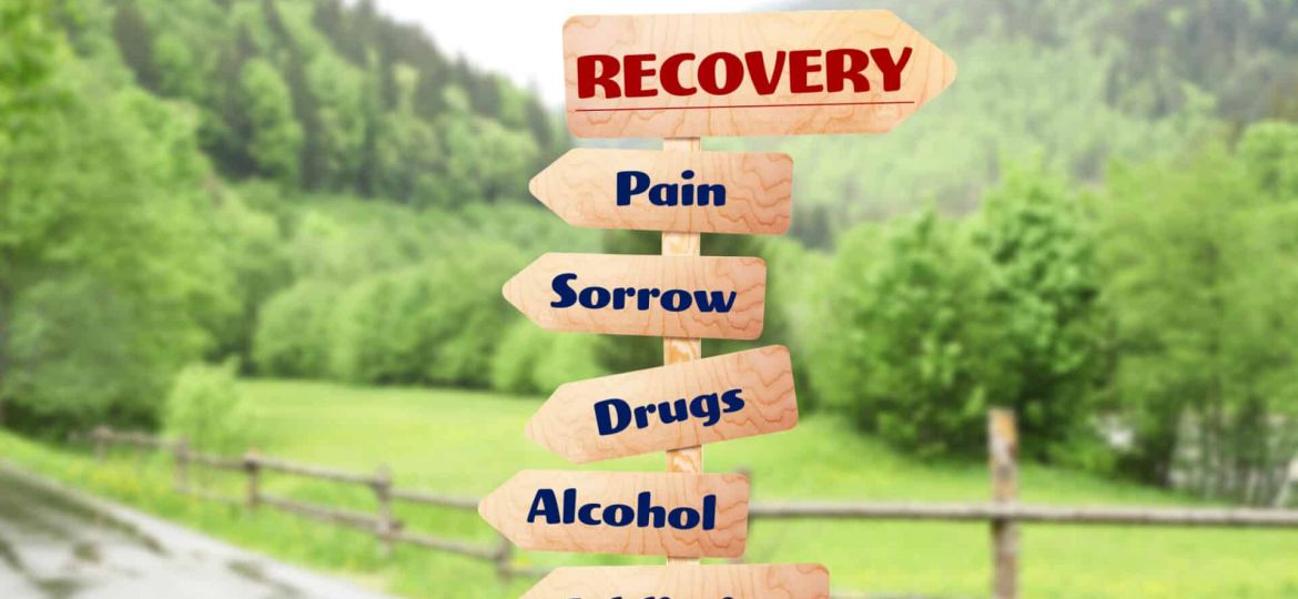 arrow signs that read "recovery" "pain" "sorrow" "drugs' "alcohol" "addiction"