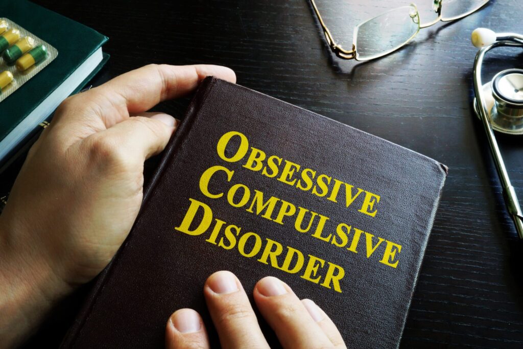a person holds a book titled "obsessive compulsive disorder"