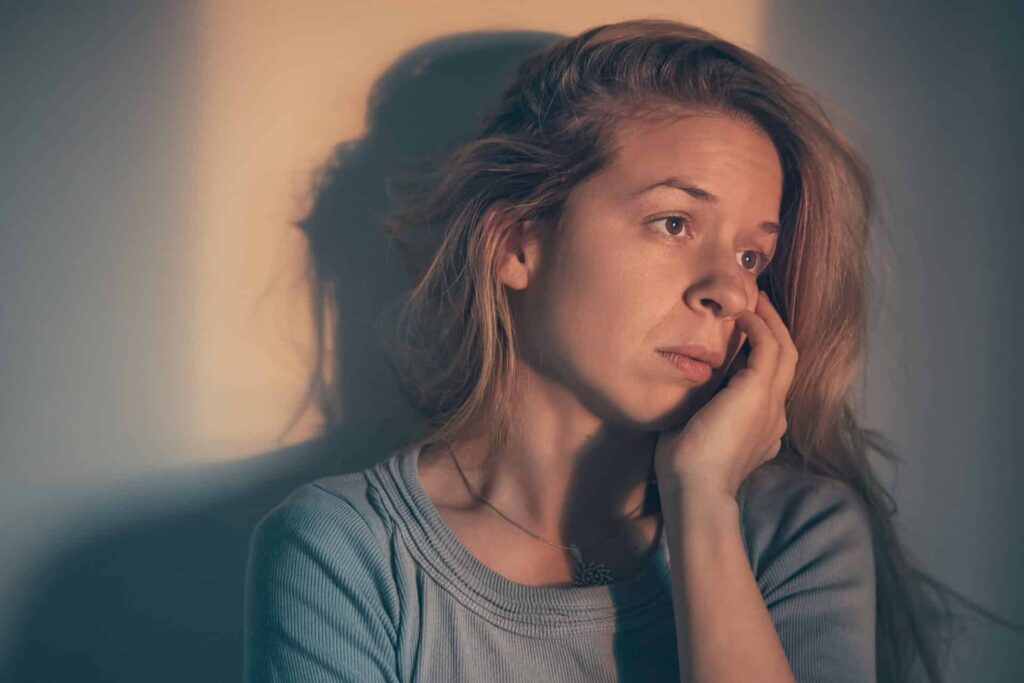 a person looks sad in a dimly lit room