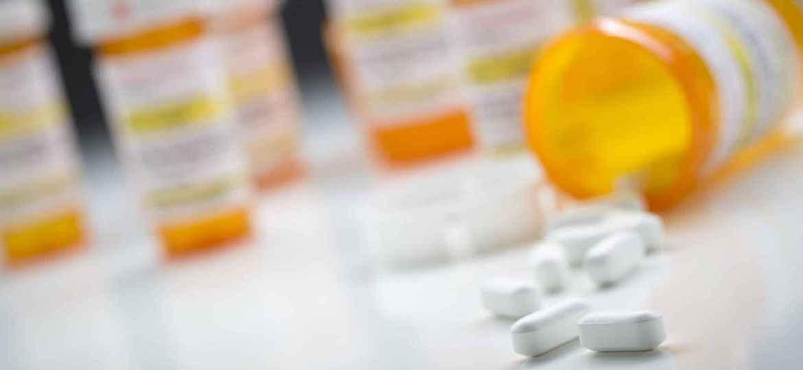 Close up of pills spilling from a pill bottle.