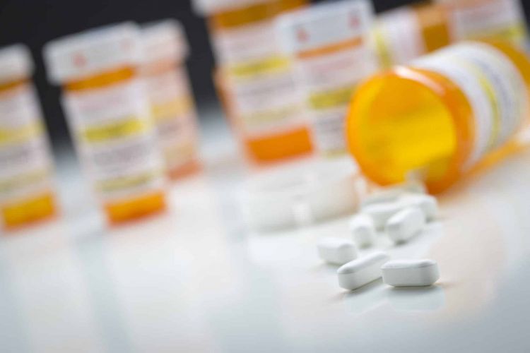 Close up of pills spilling from a pill bottle.