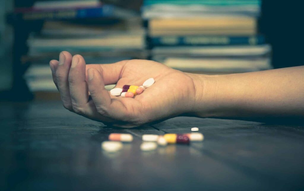 a person holds pills in an outstretched hands