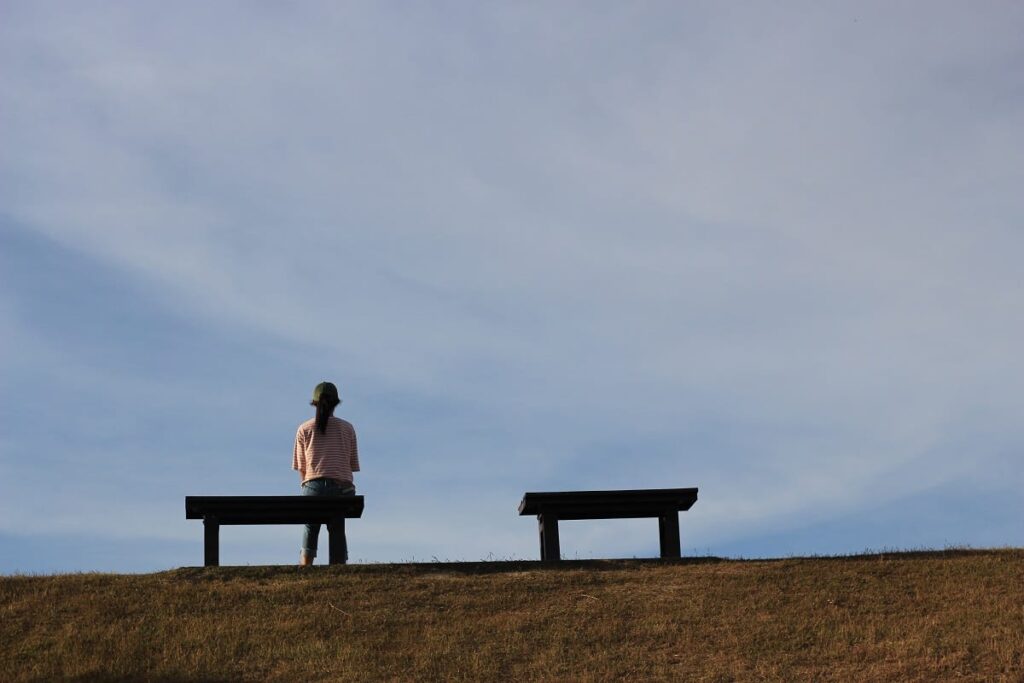 a person sits on a bench in a peaceful park