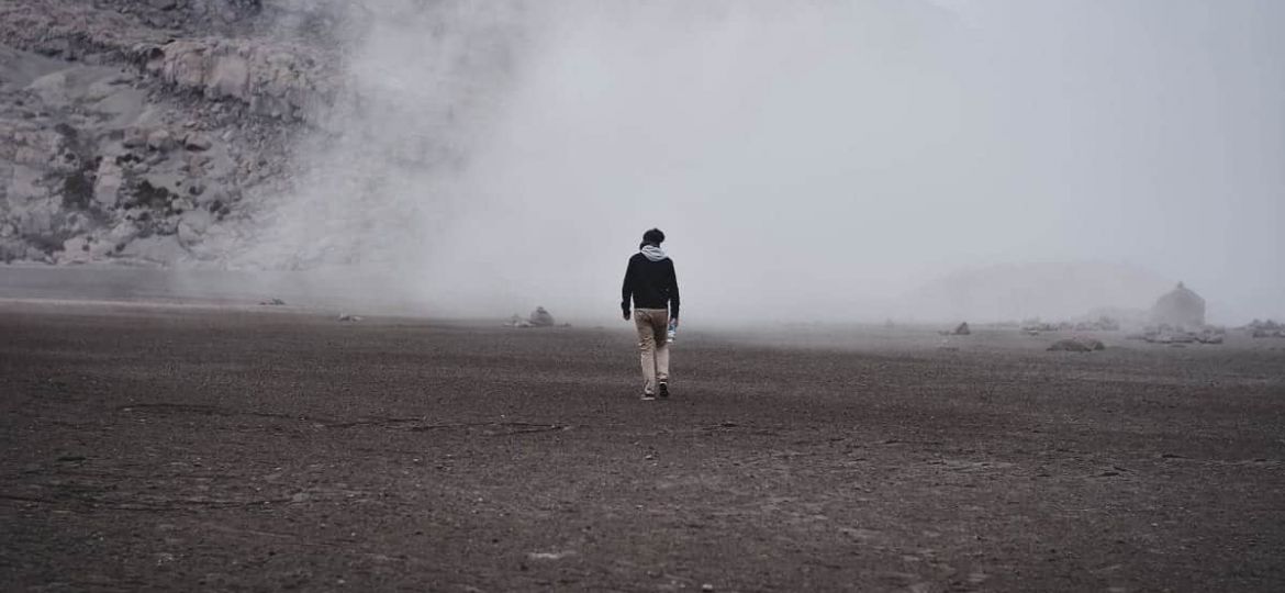 a person walks on a foggy beach