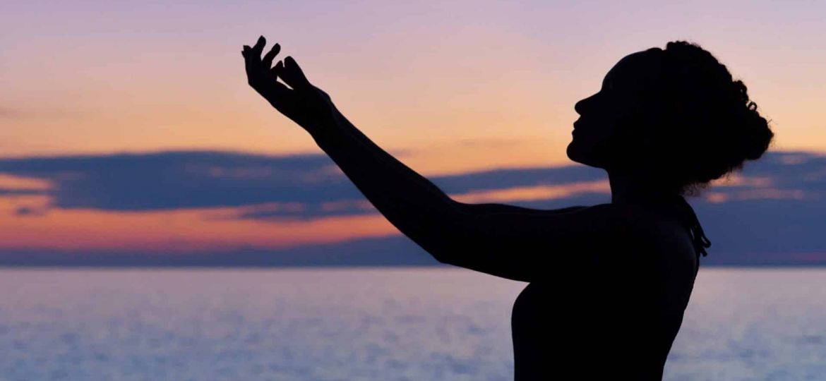 a person does tai chi on a beach at sunset