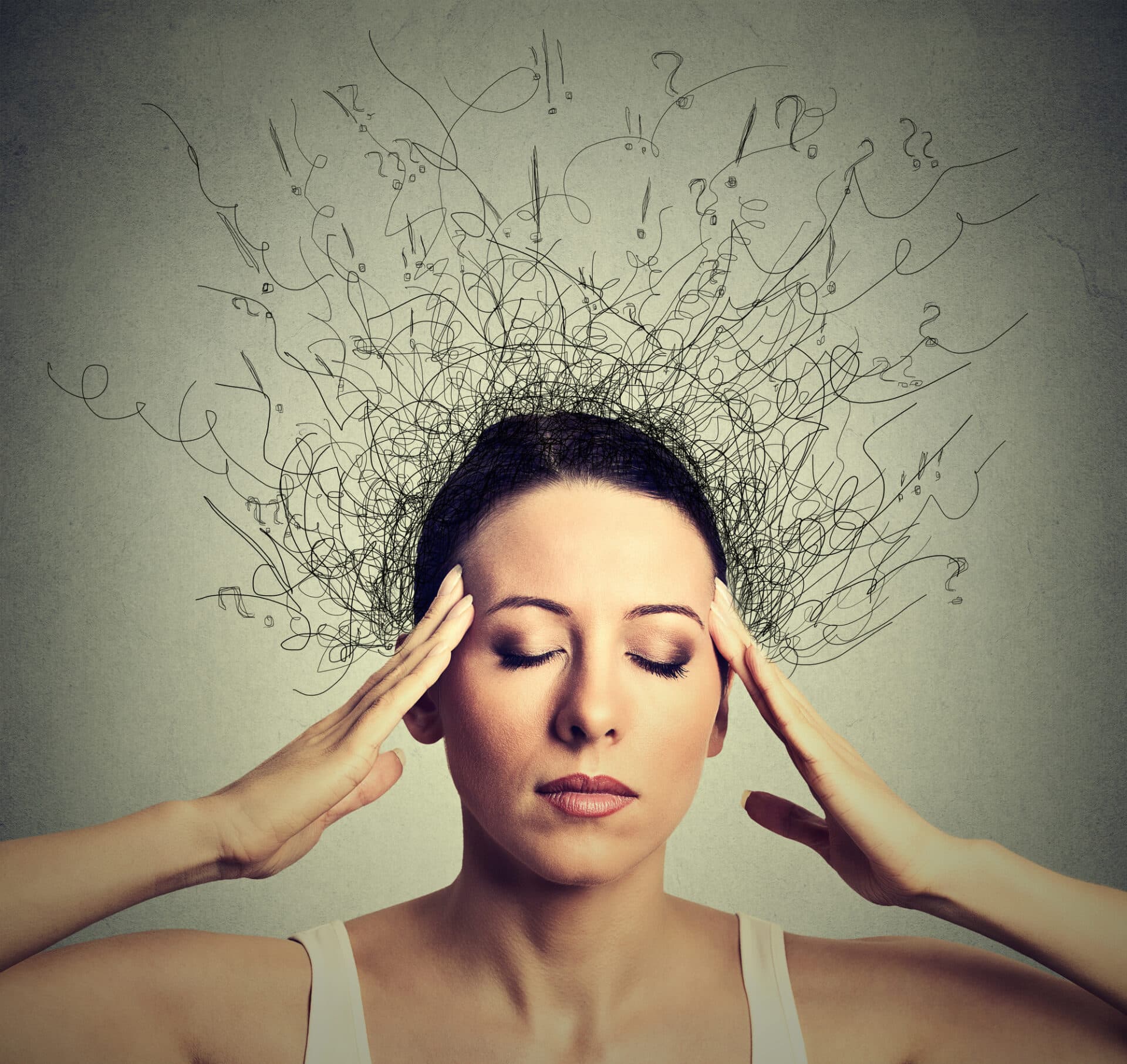 a person holds their temples in front of an artful interpretation of anxiety