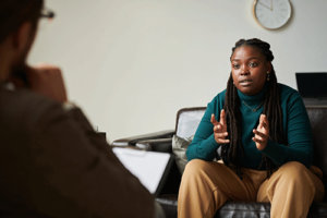 A woman talks to a therapist in dual diagnosis treatment