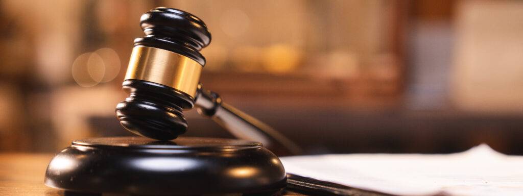 Image of a gavel on a table in a courtroom