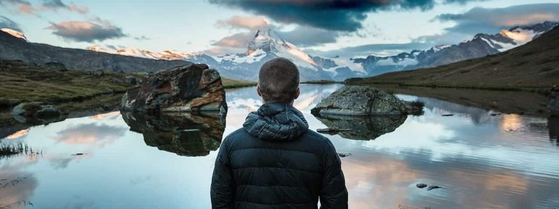 A man overlooking a mountain lake.